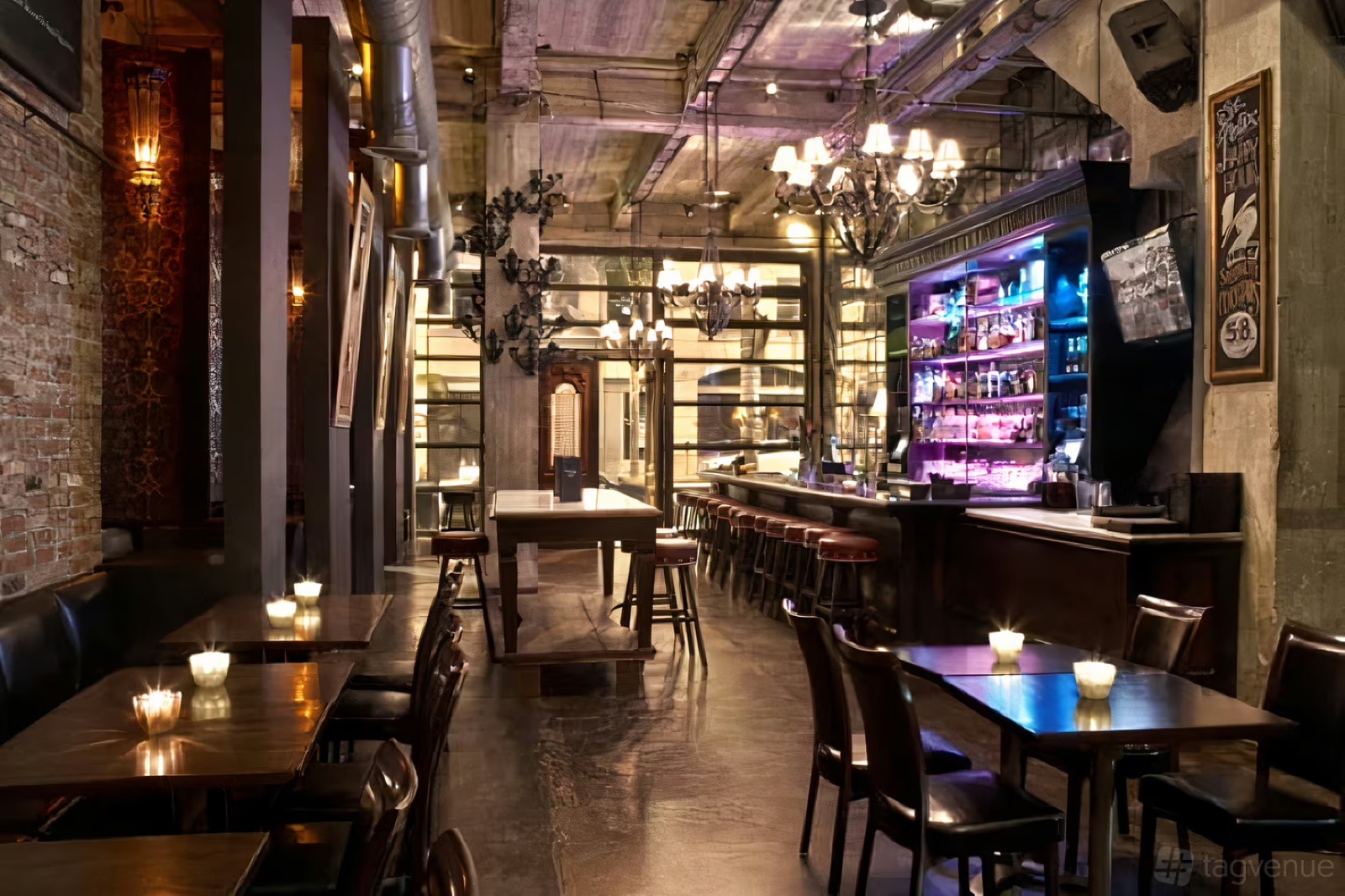 Interior of the St. Felix main room, with exposed brick, chandeliers and the bar.